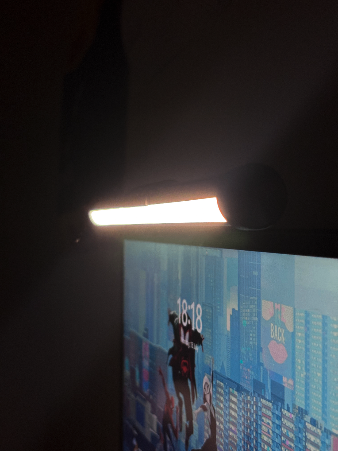 Monitor light bar glowing warm amber on a dark desk